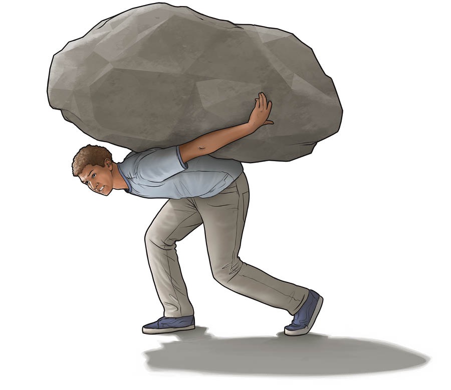 Un joven carga una piedra muy grande en su espalda.