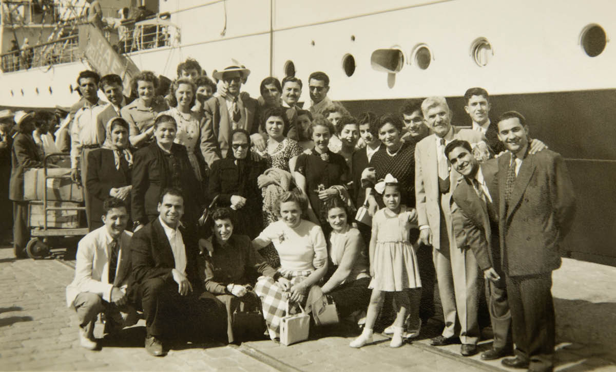 Milto con sus amigos y sus familiares al lado de un barco.