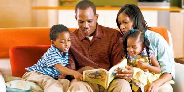 Un padre enseñando de la Biblia a sus hijos