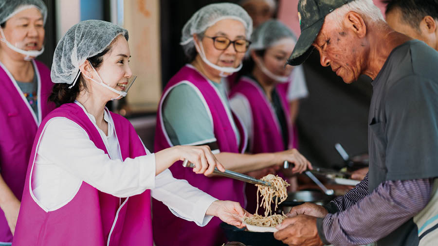La misma mujer le sirve comida a personas pobres y sin hogar.