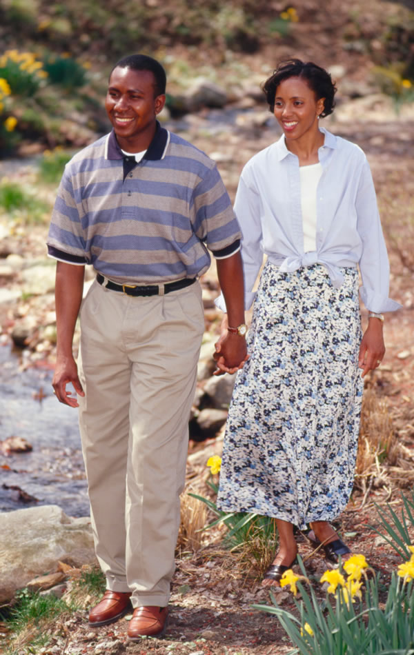 A husband and wife walking together hand in hand.