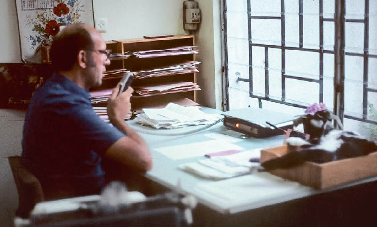 Dayrell speaking into a dictating machine in his office.