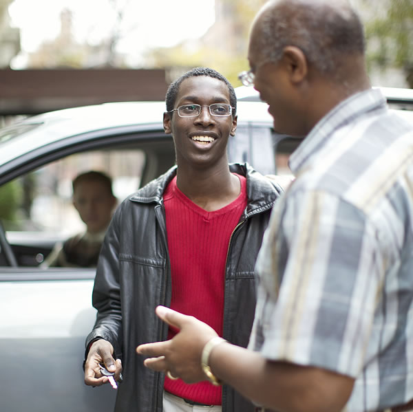 A father giving his teenage son the car keys