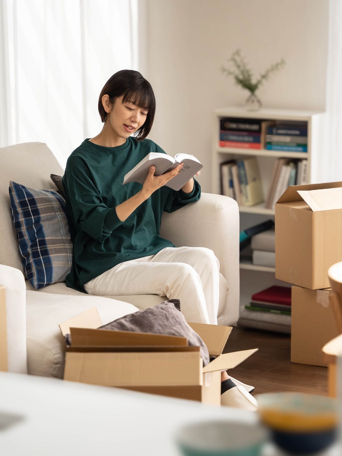 A sister taking a break from unpacking boxes to read the Bible.