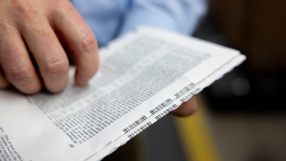 Un hermano comparando los códigos de barra de dos secciones de una biblia.