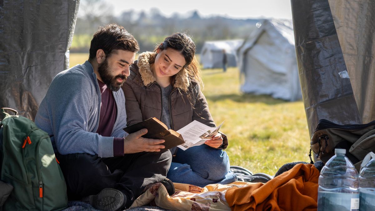 En una tienda de campaña de un campo de refugiados, un matrimonio lee la Biblia.