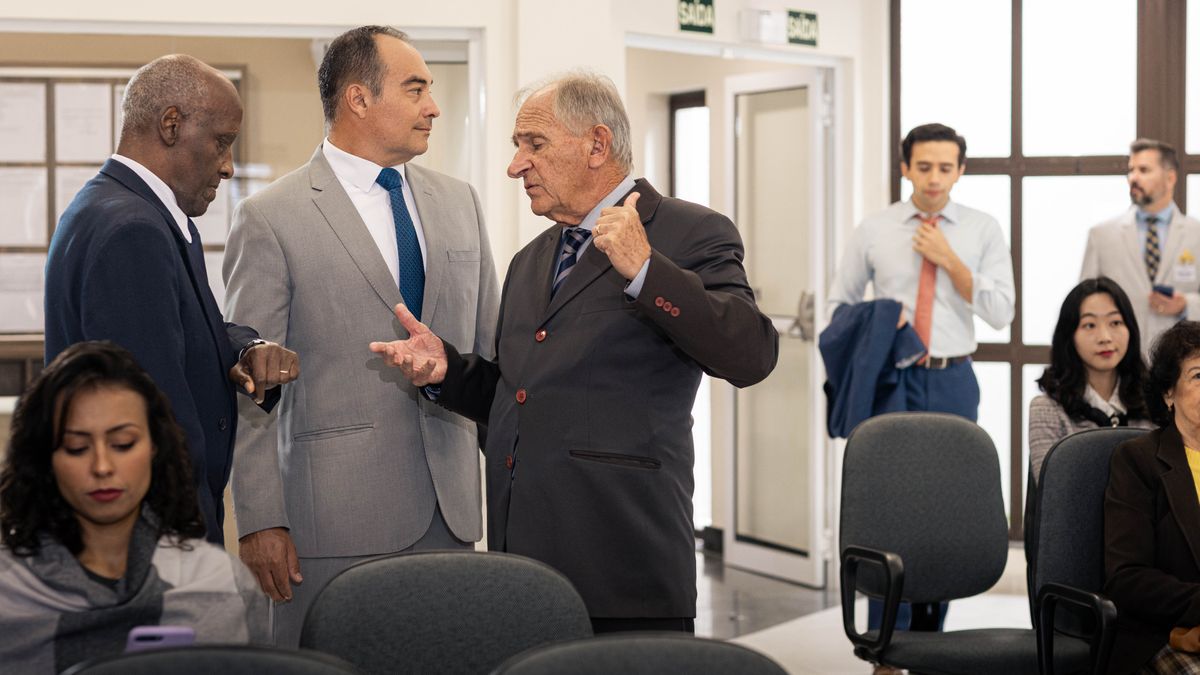 El anciano escucha a otros dos ancianos que están hablando mal de un joven que llega corriendo al Salón del Reino justo al inicio de la reunión.