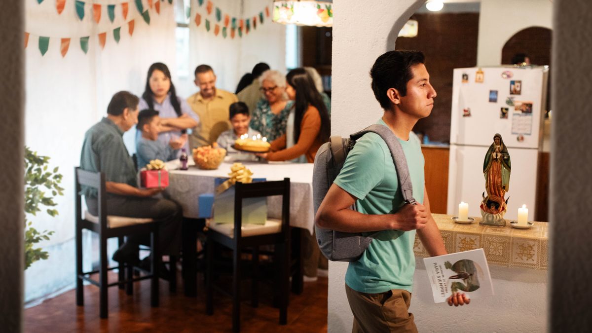 Un joven va saliendo de su casa con determinación mientras su familia celebra un cumpleaños. Lleva en la mano el libro “Disfrute de la vida”. Una de sus familiares, que no está nada contenta, lo mira con los brazos cruzados.