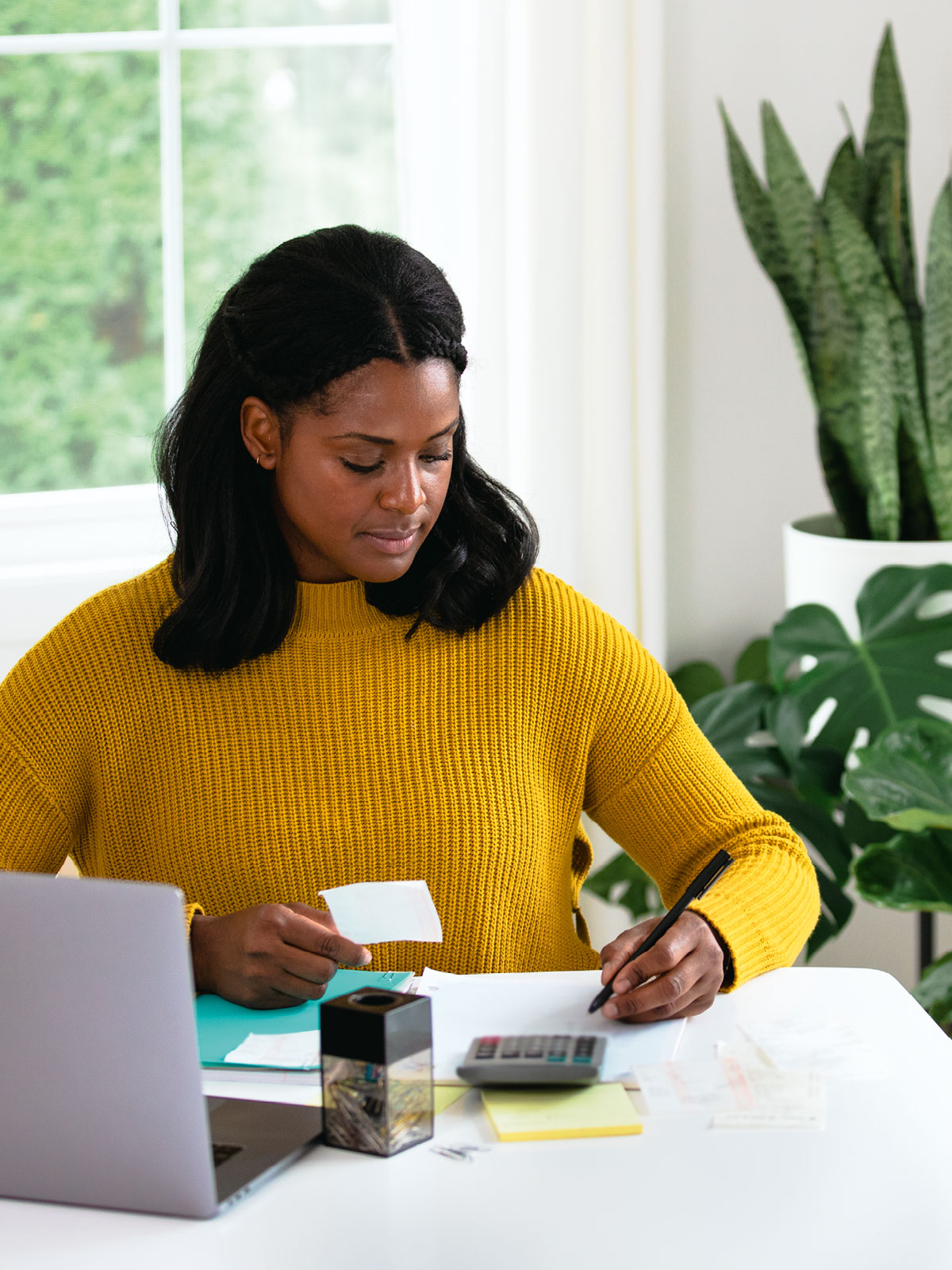 خانمی قبضهایش را با ماشینحساب محاسبه میکند.