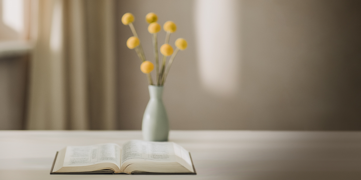 کتاب مقدّس کنار یک گلدان باز است.‏