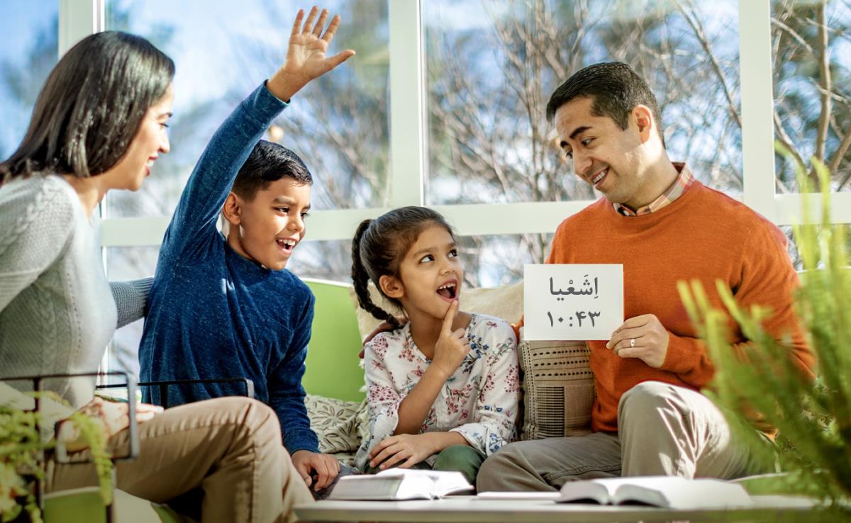 والدين طی پرستش خانوادگی با استفاده از كارت به فرزندانشان كمک می‌كنند تا آيات را به خاطر بسپارند