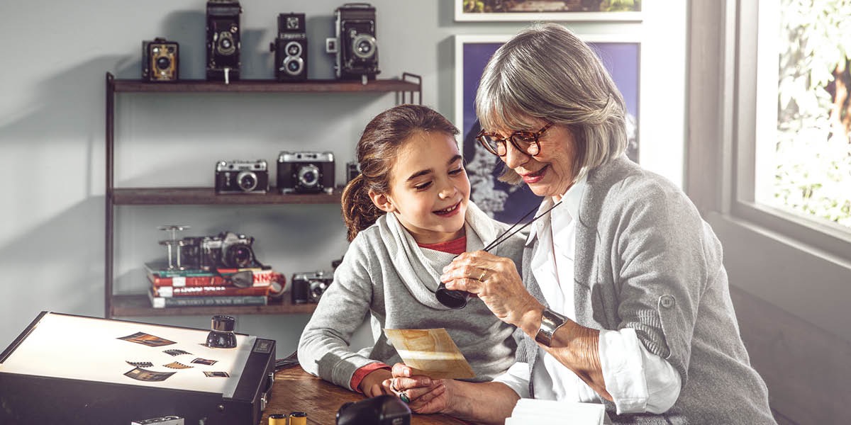 Une femme montre ses vieilles photos à une petite fille
