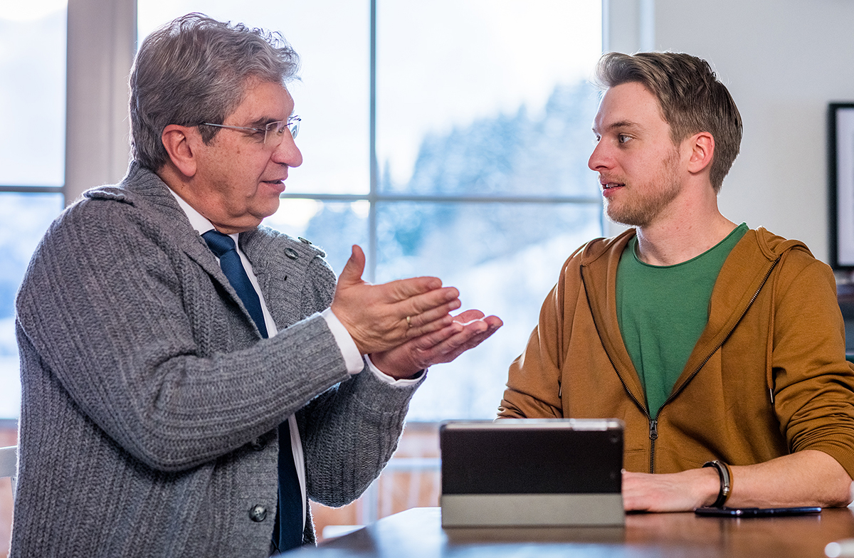 Un frère montre une vidéo sur son téléphone portable à son étudiant.