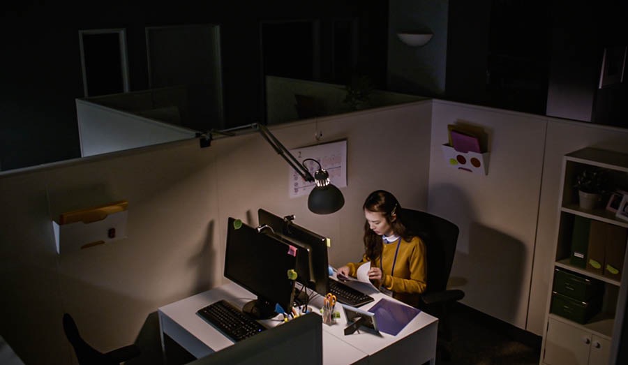La même pionnière sur son lieu de travail. Il fait sombre et seul son bureau est allumé parce qu’elle travaille tard le soir.