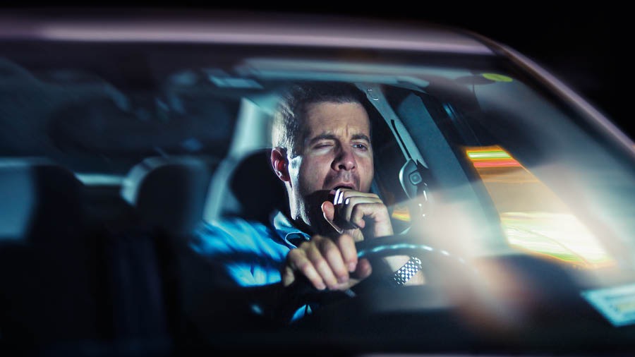 Tard dans la nuit, un frère est au volant de sa voiture. Il bâille.