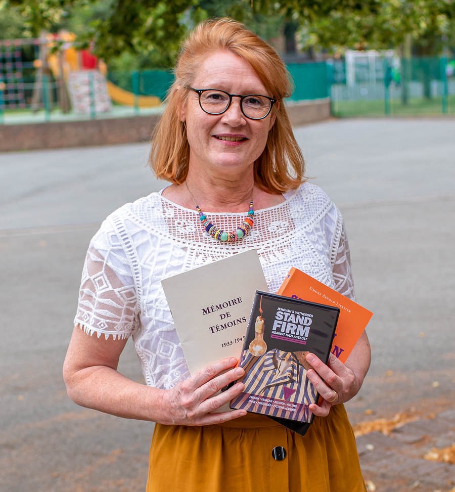 Maud pitää käsissään kolmea julkaisua.