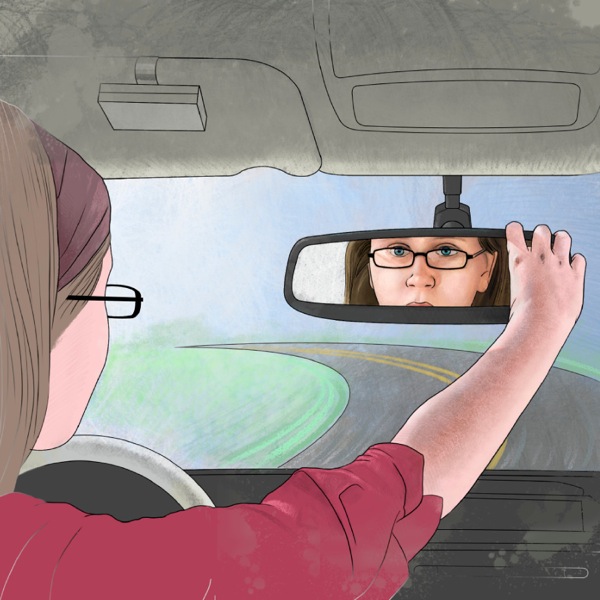 Tyttö ajaa autoa ja katsoo itseään taustapeilistä