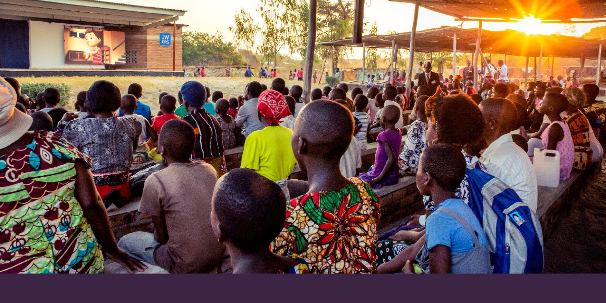 Konventtivieraat ovat kokoontuneet illalla katsomaan videoita JW Broadcastingista Malawissa.