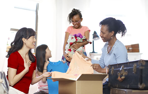 Äiti antaa vaatteita toiselle äidille