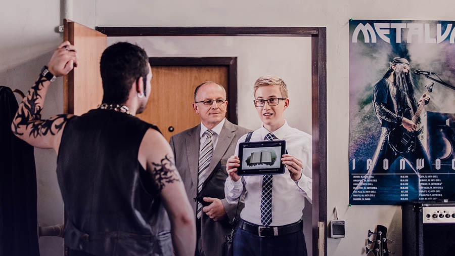 Veli näyttää kentällä videon Miksi Raamattuun kannattaa tutustua? miehelle, jolla on tatuointeja ja isoja koruja