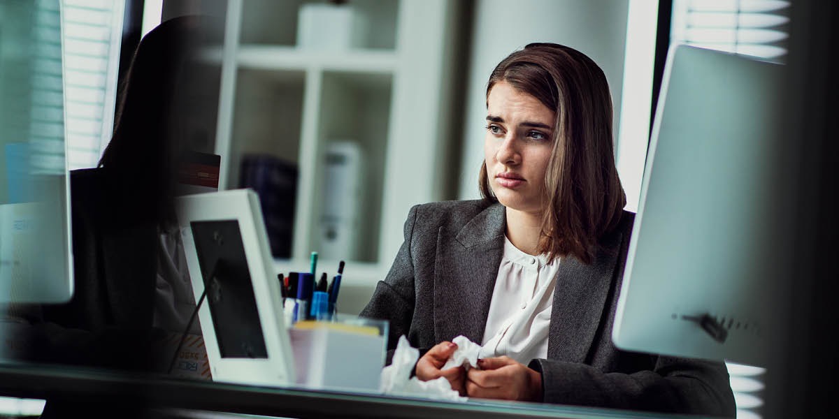 Nuori nainen itkee työpaikalla