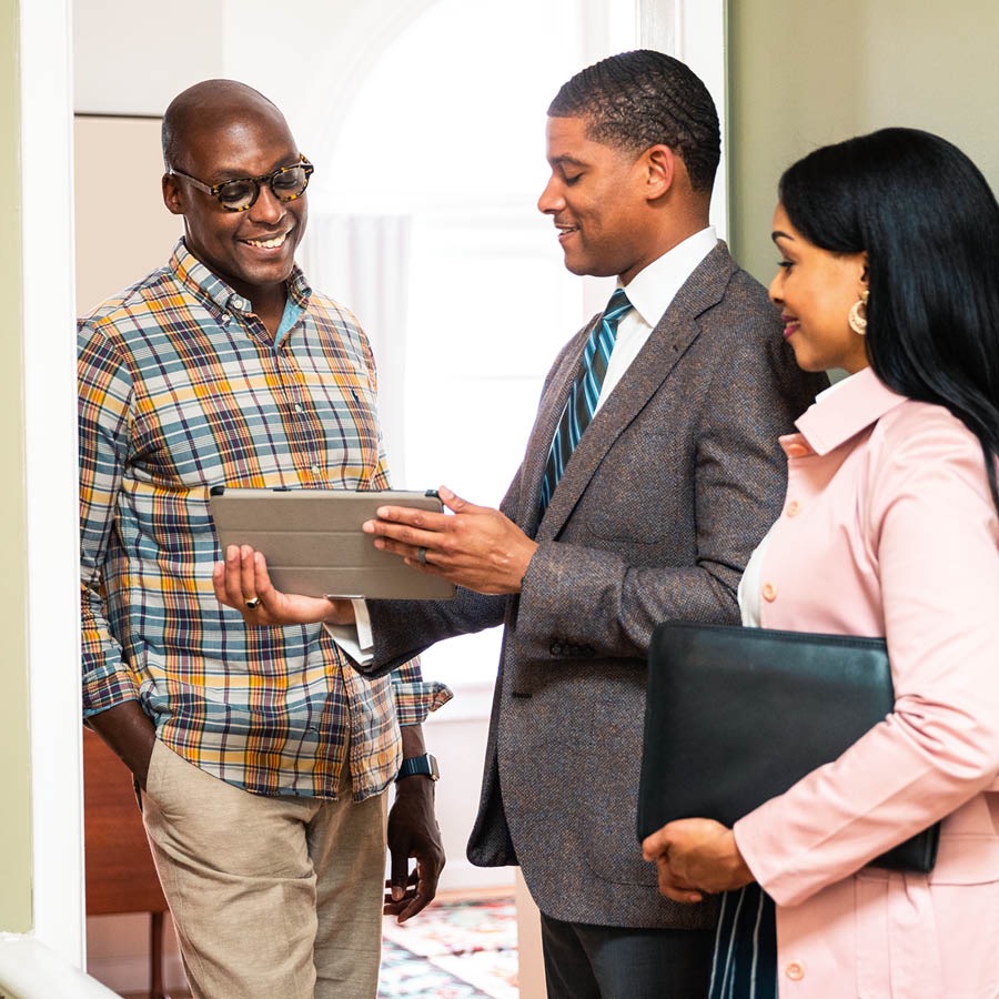 Jehovan todistajat keskustelevat miehen kanssa hänen kotiovellaan