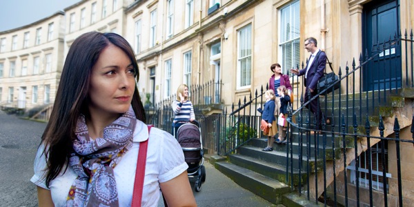 Une femme se retourne pour observer une famille heureuse