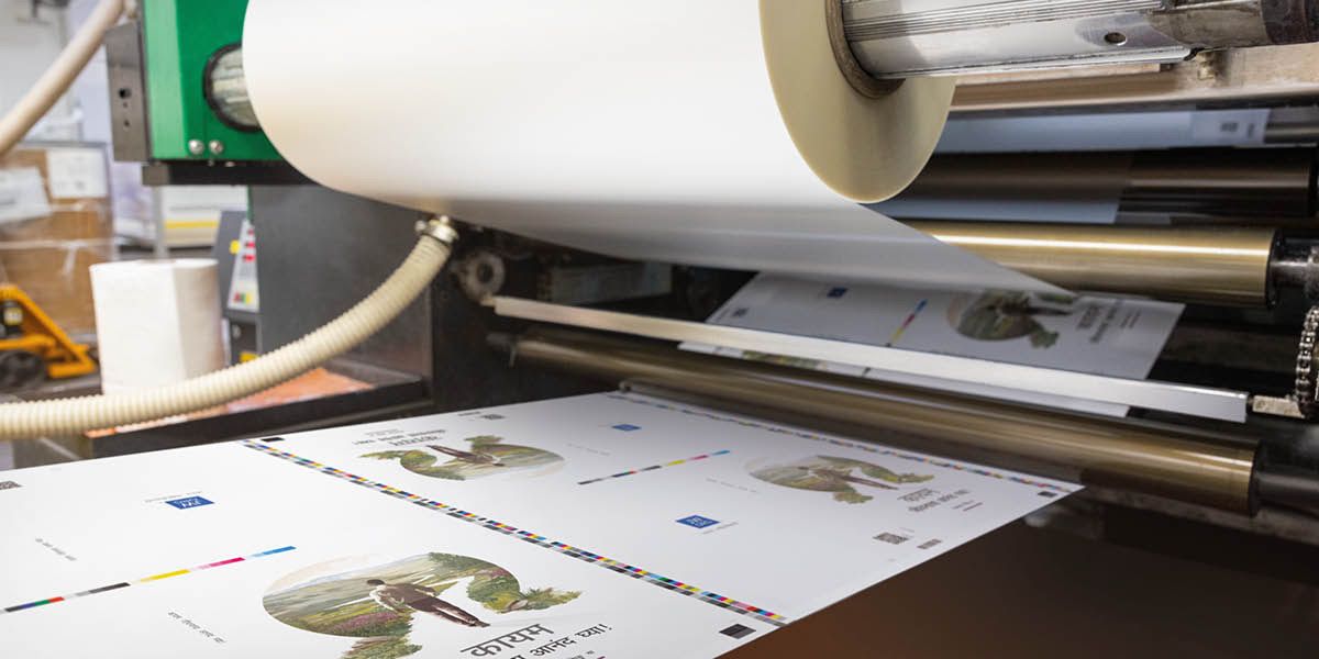 Une machine appliquant un film protecteur de laminage mat sur les couvertures des livres.