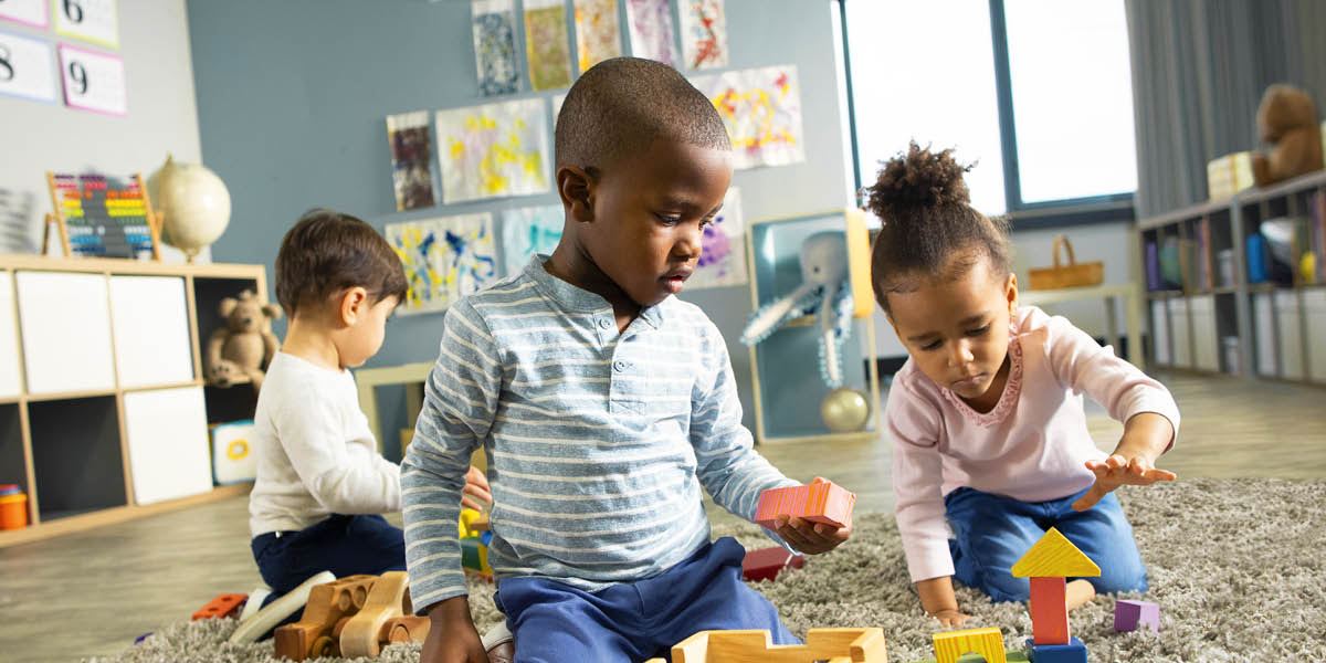 Dans une crèche, des enfants s’amusent avec des jouets.