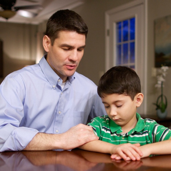 Un papa affectueux prie avec son fils