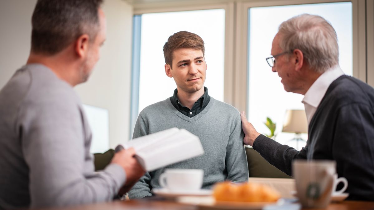Le jeune frère reçoit une visite pastorale durant laquelle deux frères l’encouragent à l’aide de la Bible.