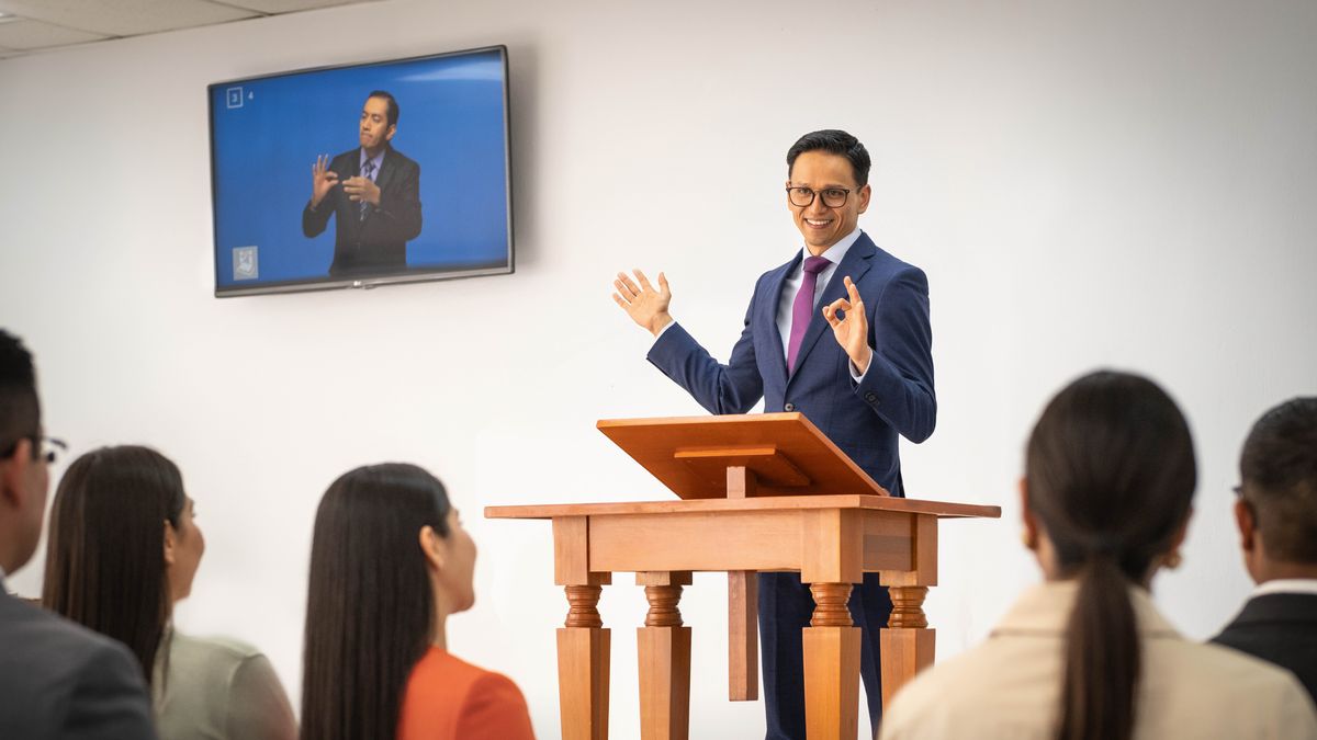 Viikkokokouksen puheenjohtaja kiittää ja neuvoo oppilasta kirjasen ”Kehity lukijana ja opettajana” pohjalta.