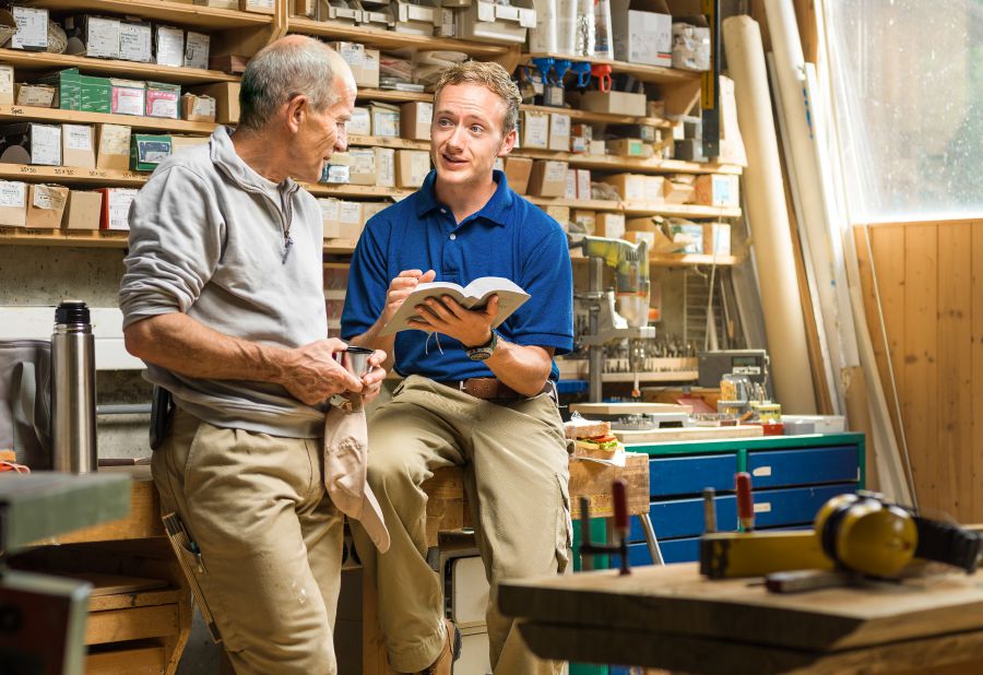 Duine d’Fhinnéithe Iehova ag roinnt an dea-scéil le fear ag an obair