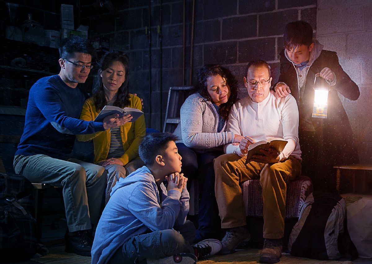 Varias familias estudando xuntas a Biblia nun soto durante a grande angustia