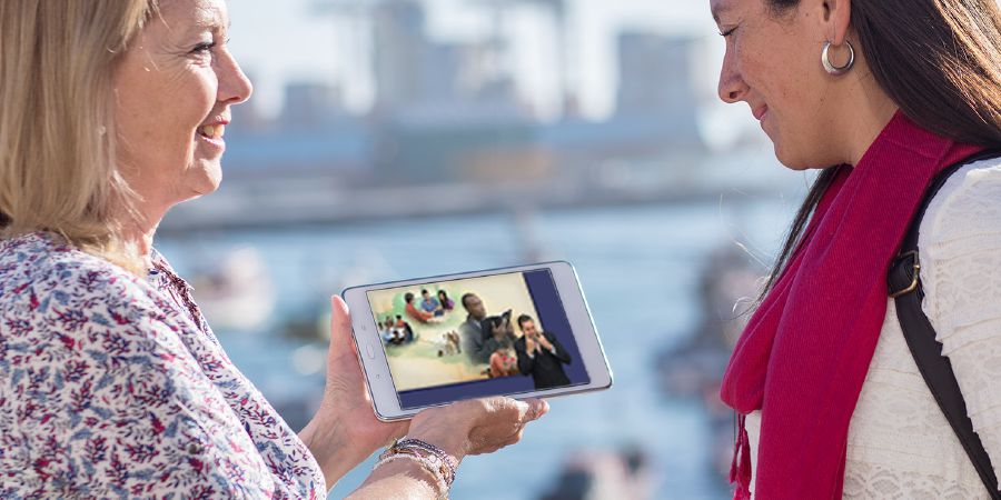 Una hermana le enseña a una señora el video ¿Por qué estudiar la Biblia?