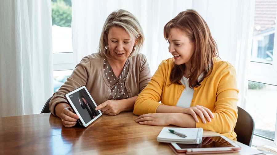 Una hermana le muestra un video a una estudiante durante un curso bíblico.