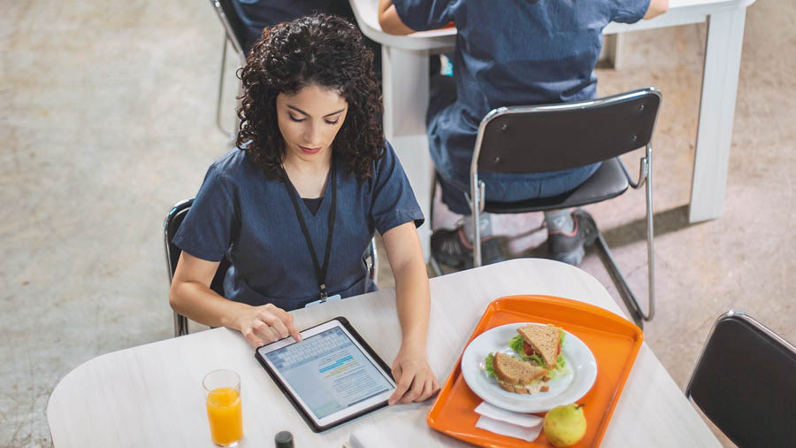 La misma hermana busca información sobre la Biblia en su tablet a la hora del almuerzo en el trabajo.