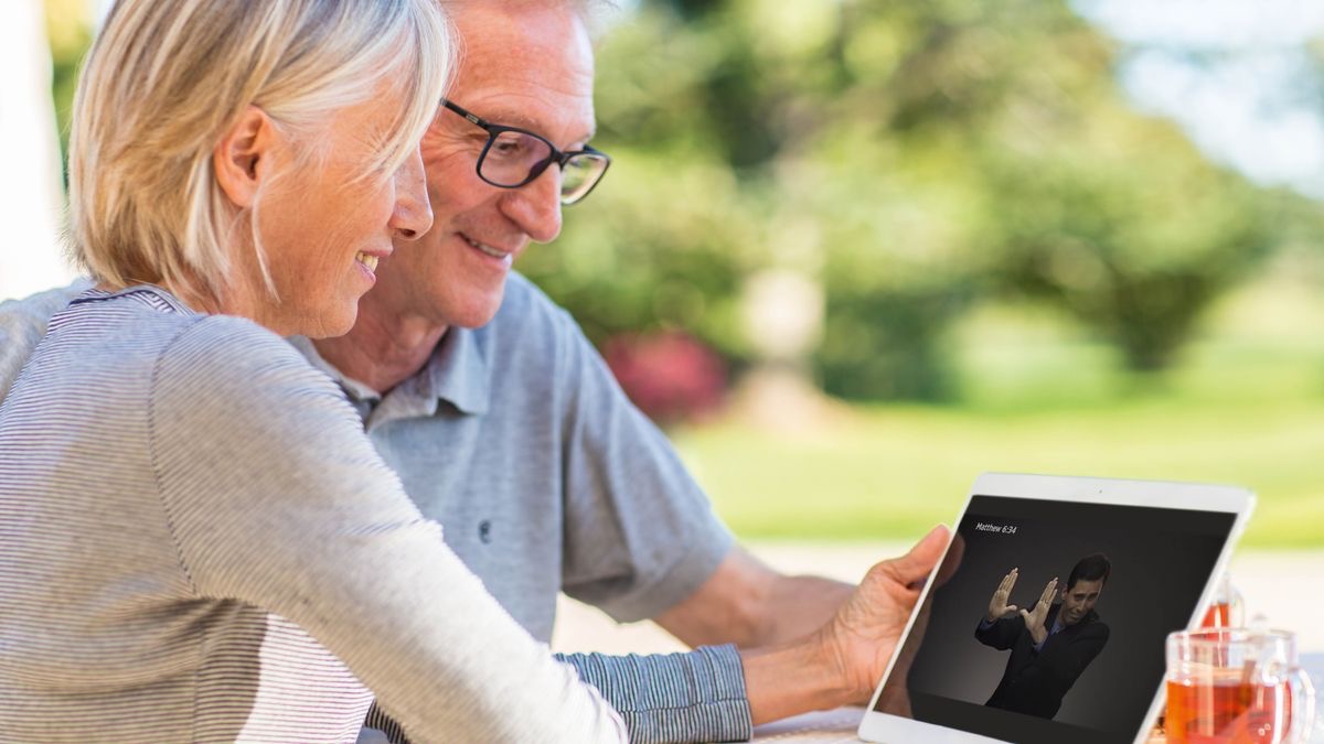 Una hermana lleva puestos unos audífonos o auriculares y escucha una grabación de audio en su tableta.