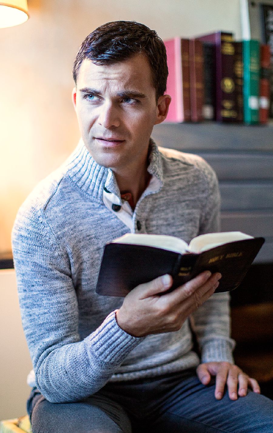 Un hombre sostiene una Biblia con la mano y expresa dudas con su mirada