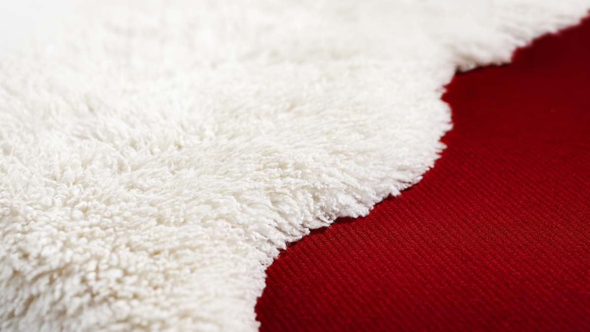 צמר לבן לצד שטיח אדום.‏