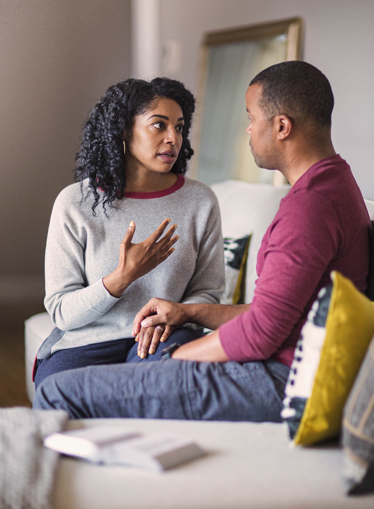 Tus pojniam nrog nws tus txiv tham. Muaj ib phau Vajlugkub nyob ntawm nkawd ib sab.