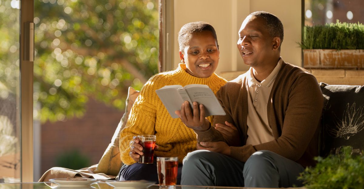One husban an wife happy fo read da Bible togedda.