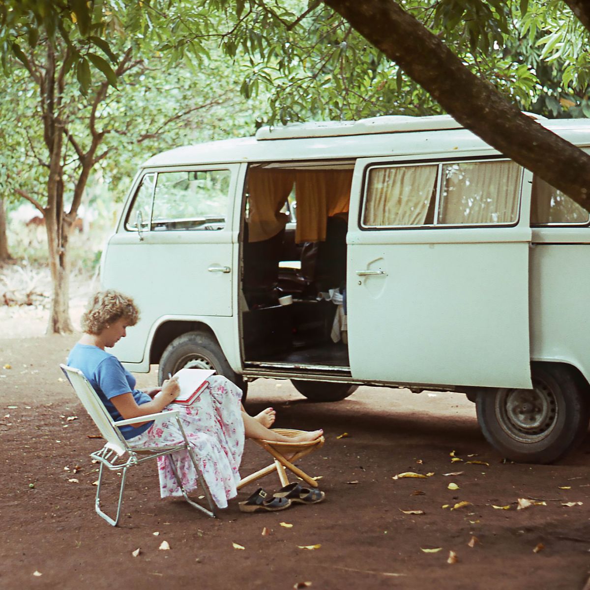 Ann-Catrin sitting on one folding chair right outside dea Volkswagen Kombi van.