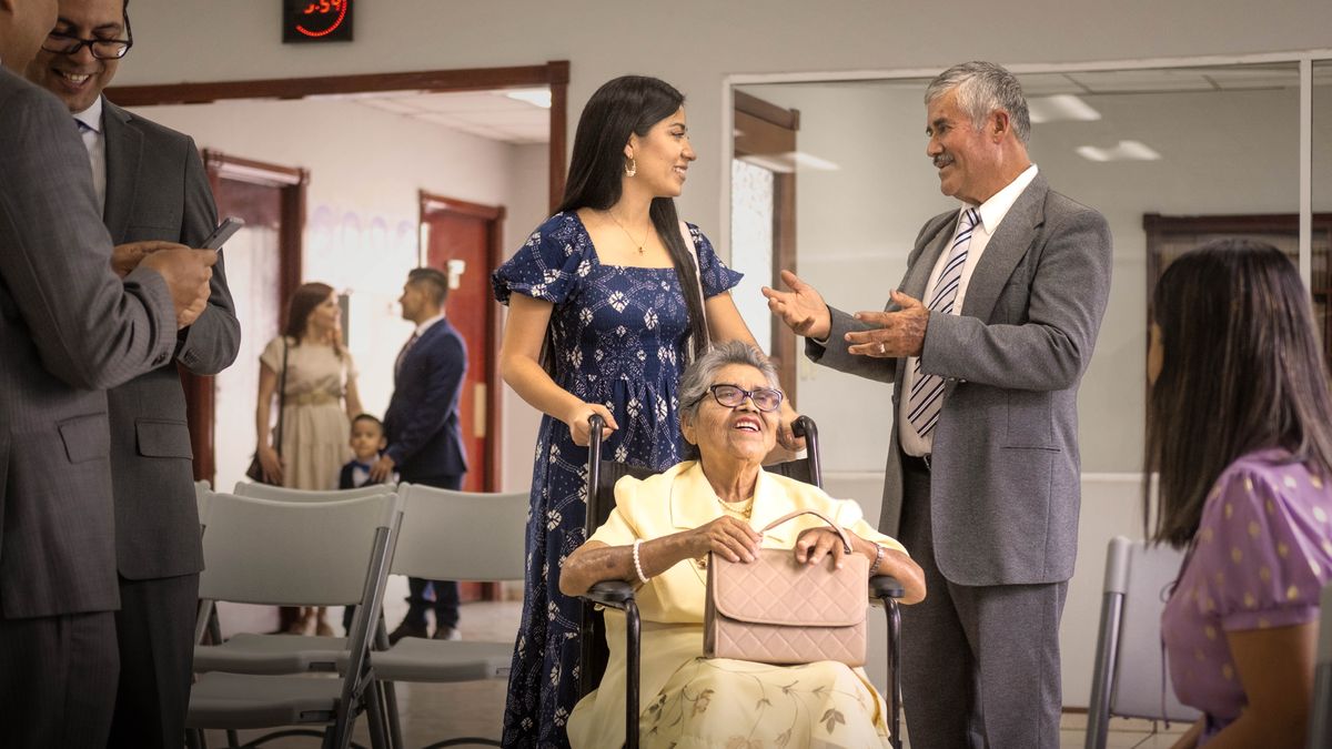 Un anziano loda una sorella che sta accompagnando un’altra sorella che è sulla sedia a rotelle.