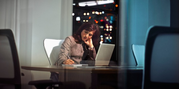 Donna stressata che fa straordinari