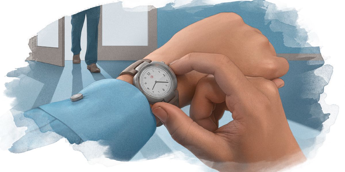 Un uomo controlla l’orario sul suo orologio mentre un altro uomo entra nella stanza