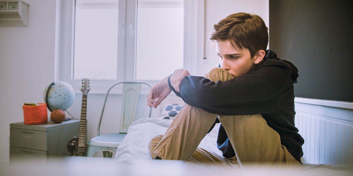 Un ragazzo depresso seduto sul letto