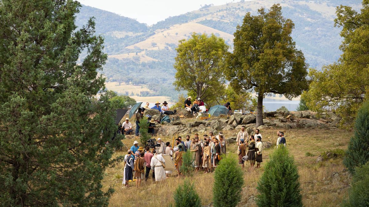 Si gira una scena in un luogo isolato circondato da colline e alberi.