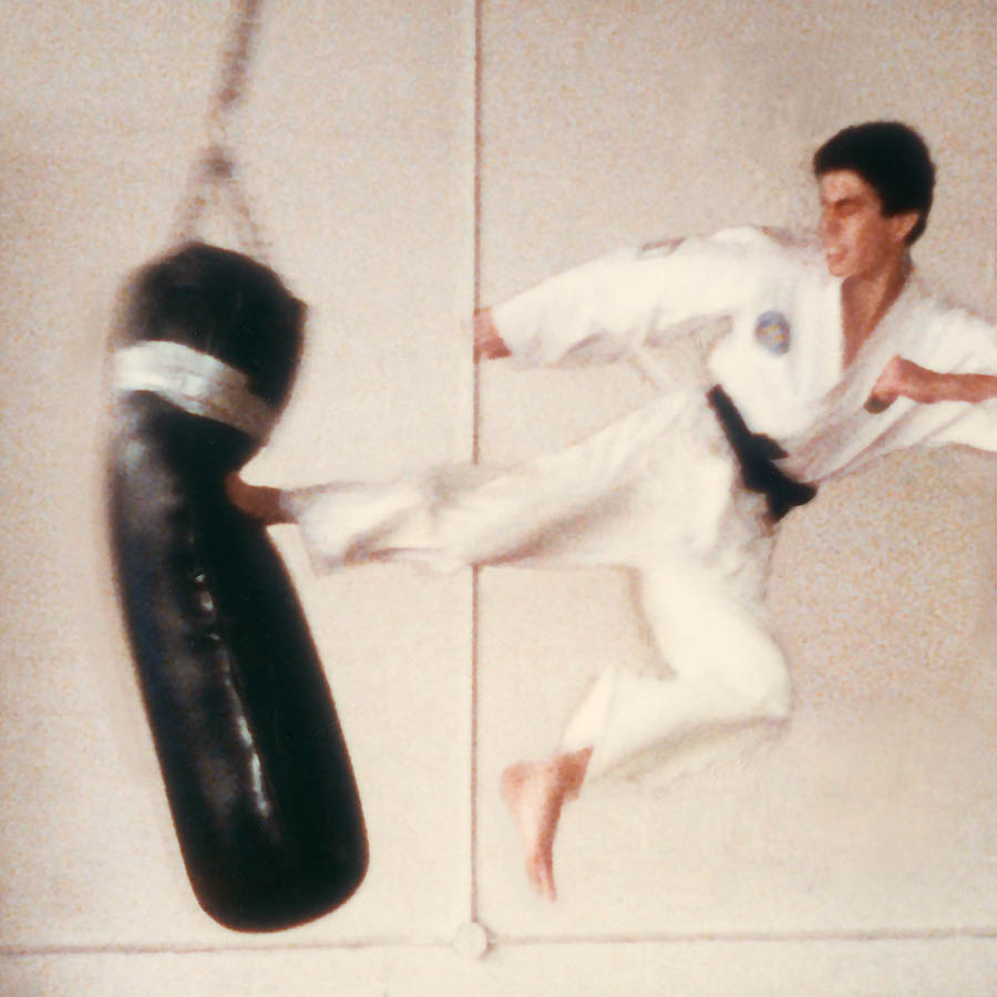 Erwin sferra un calcio laterale contro un sacco da boxe.