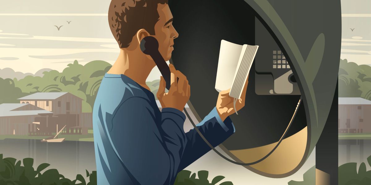 Un ragazzo studia la Bibbia tramite un telefono pubblico.